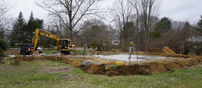 A man standing next to a hole in the ground.