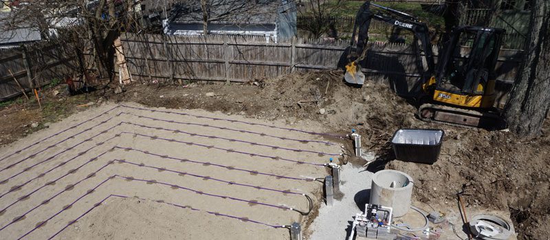 A construction site with a backhoe and some sand.