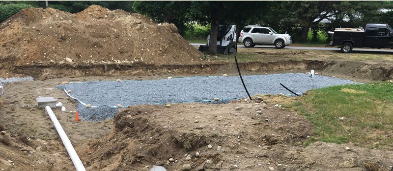 A truck is parked near the water and dirt.