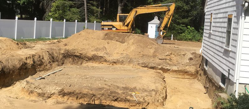 A yellow and black excavator on top of dirt.