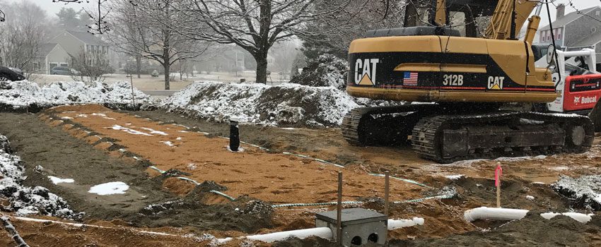 A cat tractor is parked in the snow.